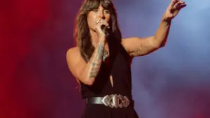 Ella Langley singing into a microphone under stage lights during a 2026 Dandelion Tour arena show